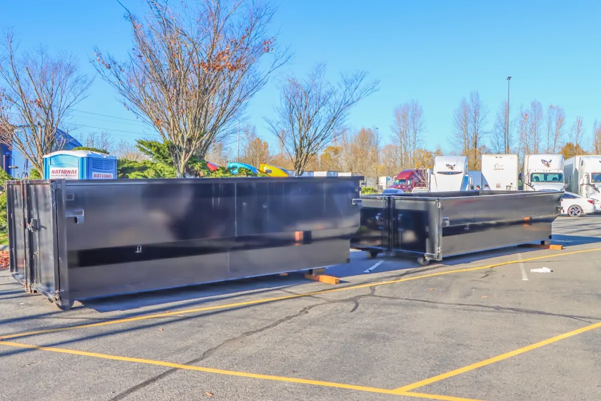 Professional dumpster rental service with roll-off container on residential driveway in Everman